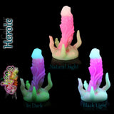 Dildo fantasy Chaos in silicone nel colore Heroic fosforescente, mostrato alla luce naturale, al buio e sotto luce nera