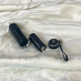 Zwarte UV-zaklamp naast witte productdozen op een achtergrond van zilverkleurige stof
