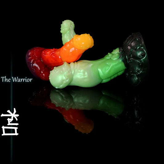 Diversi dildo in silicone fantasy ispirati agli ork, verdi, rossi e arancioni, esposti su superficie nera riflettente con texture scolpita da creatura e base ampia.