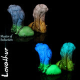 Dildo fantasy alieno Lovathur di Love Smiths mostrato in due colorazioni, con texture biomeccaniche e base scolpita, design Master of Seduction.