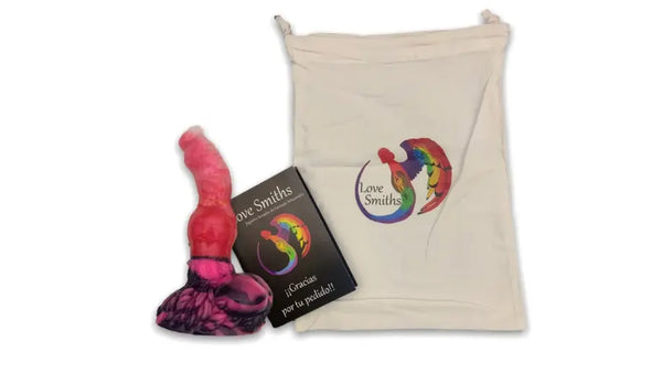 Produktpräsentation mit einem pinken Fantasy-Silikontoy mit dunkel marmoriertem Sockel, einer Love-Smiths-Dankeskarte und einem cremefarbenen Zugbeutel mit Love-Smiths-Logo.