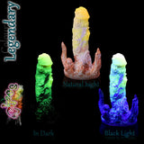 Dildo fantasy Chaos in silicone nel colore Legendary fosforescente, mostrato alla luce naturale, al buio e sotto luce nera